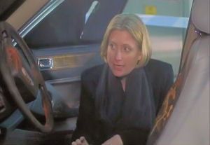 Angie looks at the remains of the car